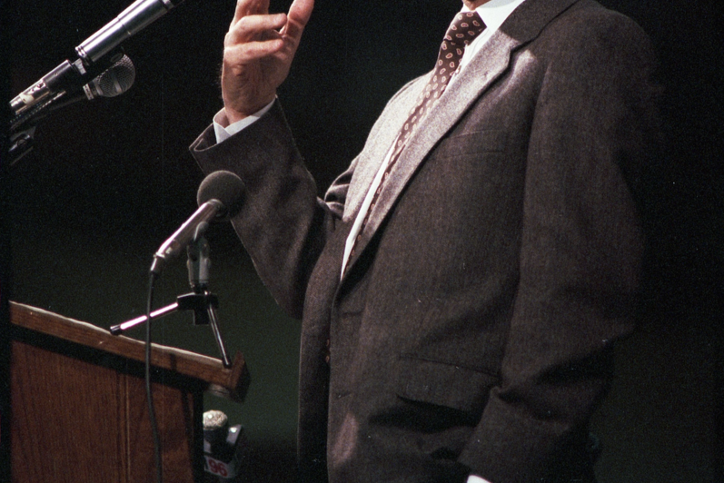 Stephen Lewis gestures while speaking at a lectern.