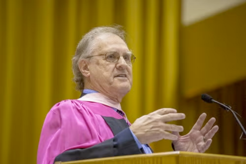 Stephen Lewis in convocation regalia while addressing the audience.