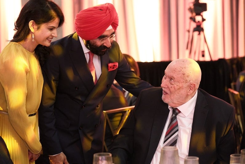 Jagdeep Singh Bachher greets a sitting Paul Guild.