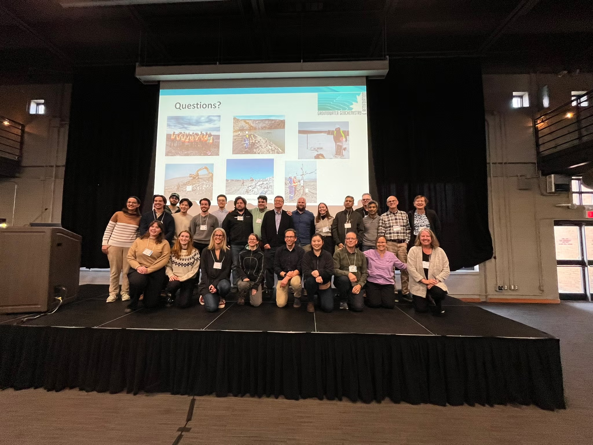 A group of postdoctoral fellows, research faculty, students and staff on stage.
