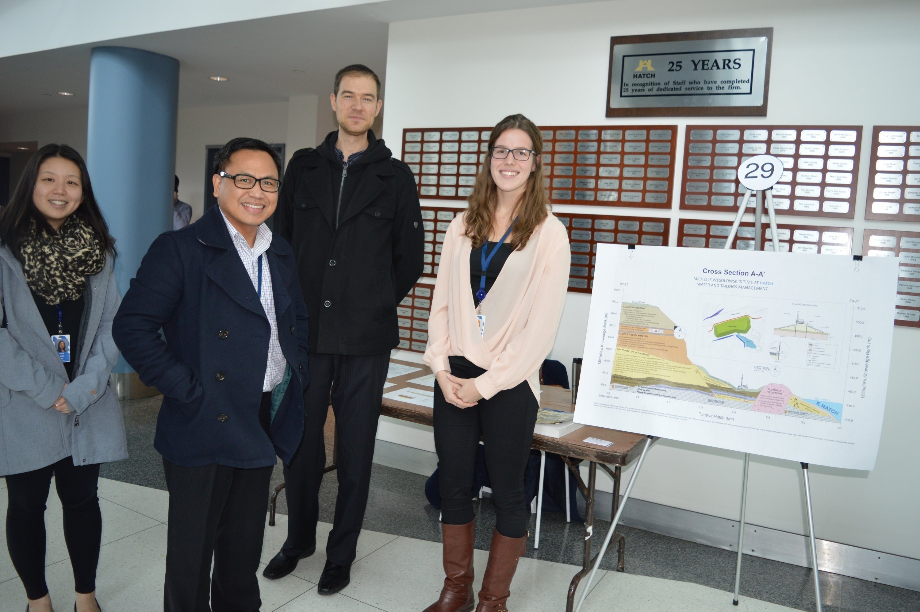 Michelle Wesolowski poses with her presentation and three unidentified individuals.