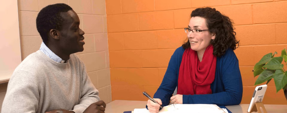 A learning skills support worker and a student in conversation.