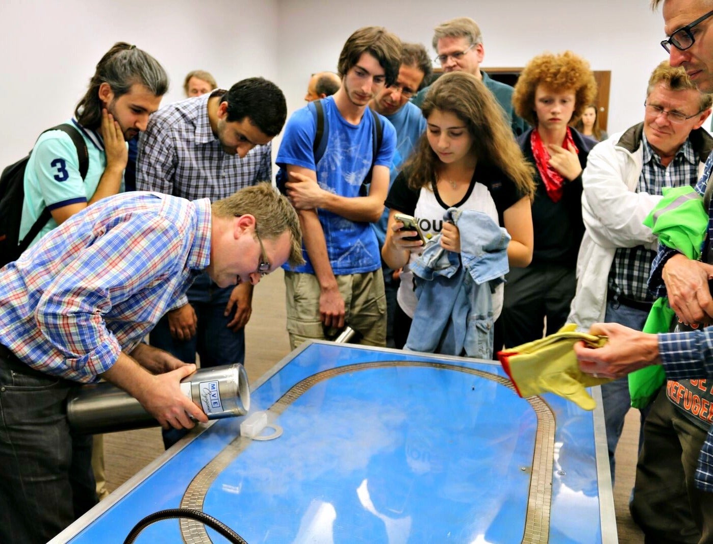 A scientific demonstration as a crowd looks on.