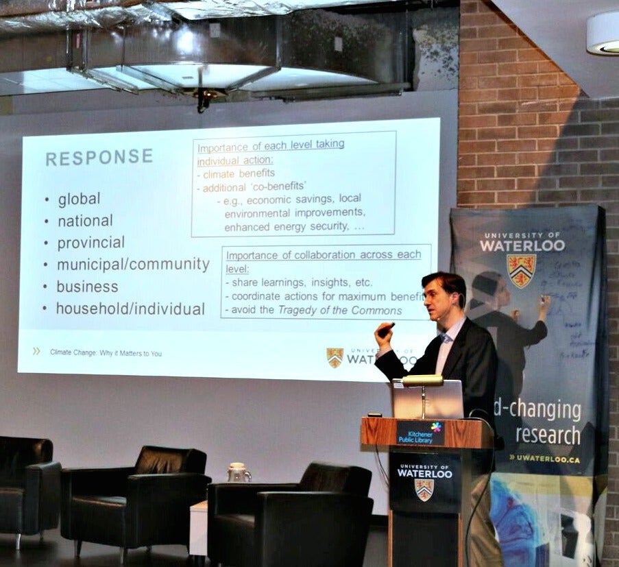 A man delivers a presentation while speaking at a podium.