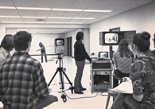 John Pezzack (standing at the TV cart, looking at screen) teaching a Kinesiology biomechanics lab.