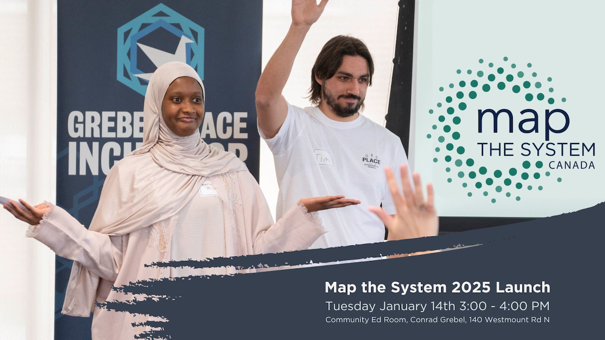 A man and a woman pose at a podium with the Map The System logo on the wall behind them.