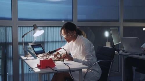 female student at lab desk working on electronics