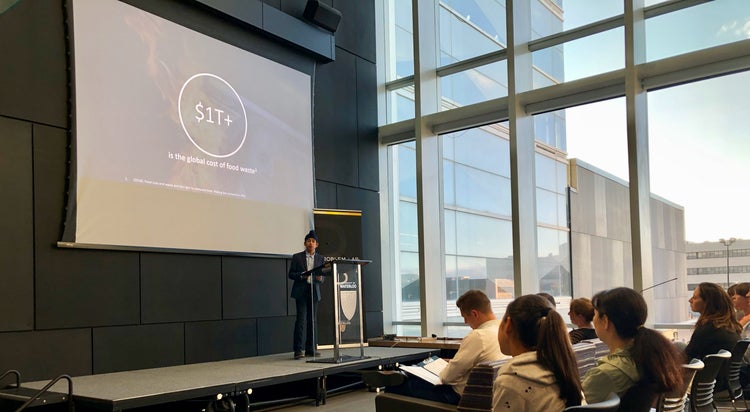 A student presents on stage during the Problem Pitch event.