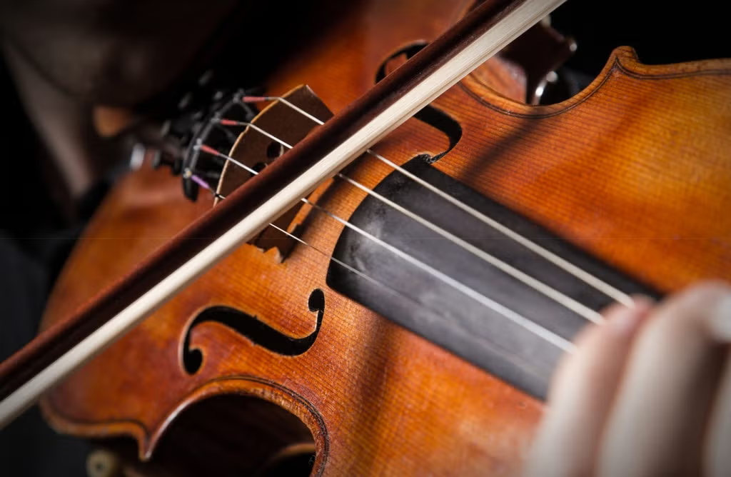A bow being drawn across a violin's strings.