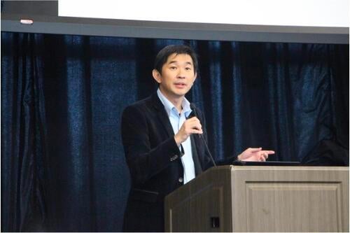 Ken Seng Tan speaks at a podium.