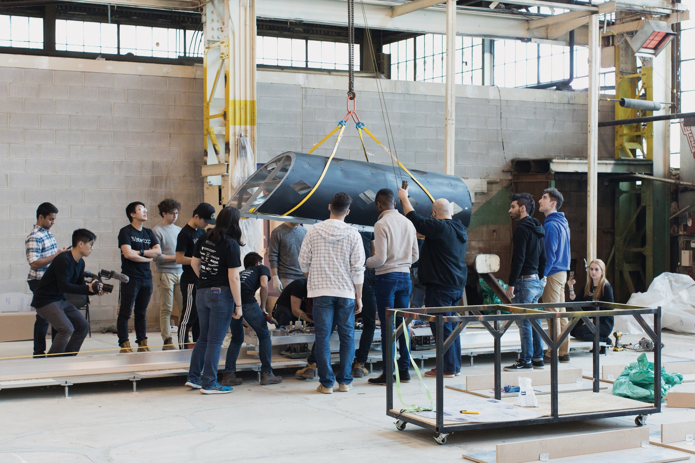 Waterloop team members move the Goose 1 prototype on a crane.