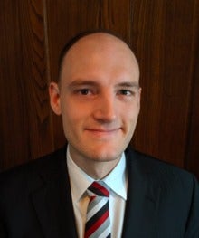 Headshot of Preston Arens in a suit and tie