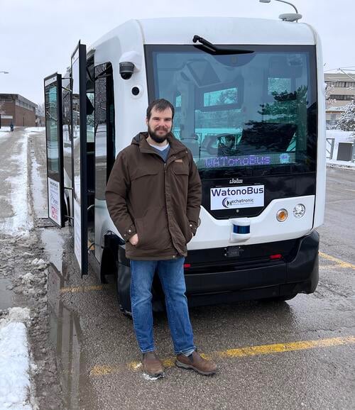 Aaron Sherratt, WATonoBus technician, poses in front of the shuttle's Davis Centre stop.