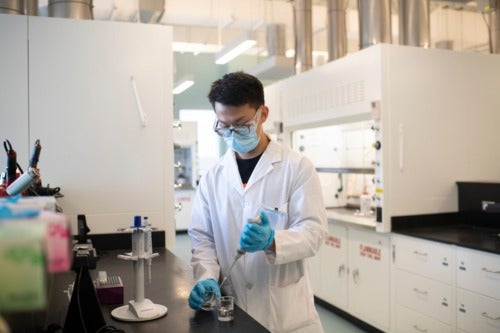 A masked worker in a laboratory.