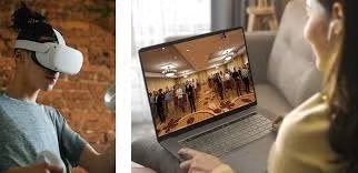 A person wears a VR headset while another person engages in a laptop simulation.