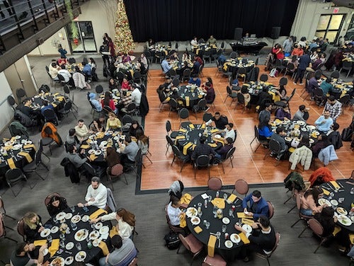 International students at tables in Fed Hall for a holiday dinner.