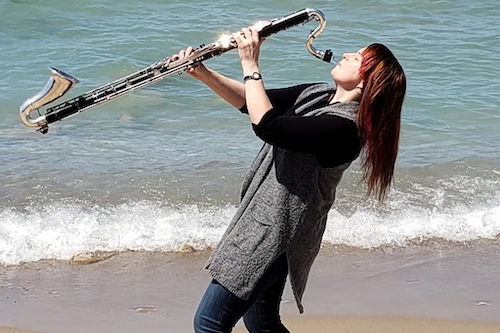 Dr. Kathryn Ladano plays a bass clarinet on the beach.
