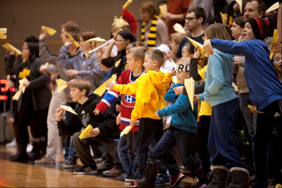 Children throw paper airplanes as part of the airplane toss event.