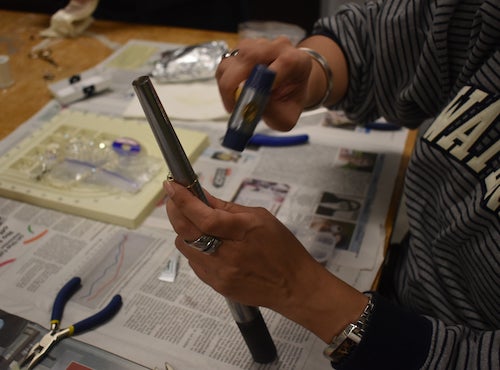 A person uses tools to repair a ring.