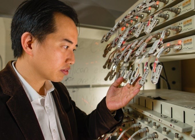 Zhongwei Chen and a bank of electrical equipment.