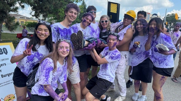 Dean Mary Wells poses with Engineering students who all wear purple tie-dyed shirts.