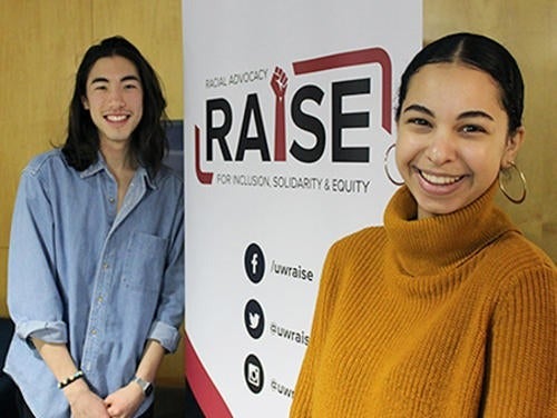 RAISE service volunteers pose with the service logo banner.