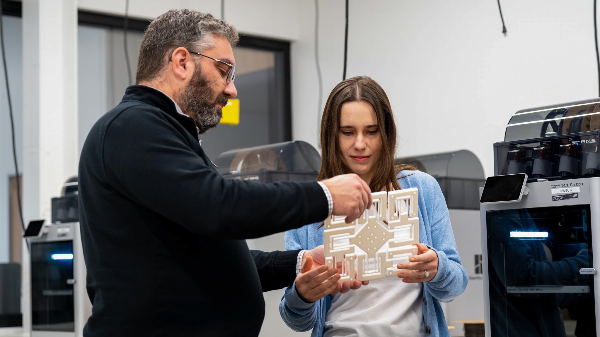 Dr. Mathieu Maisonneuve and Dr. Alex Maierean examine a photonics sensor in a lab.