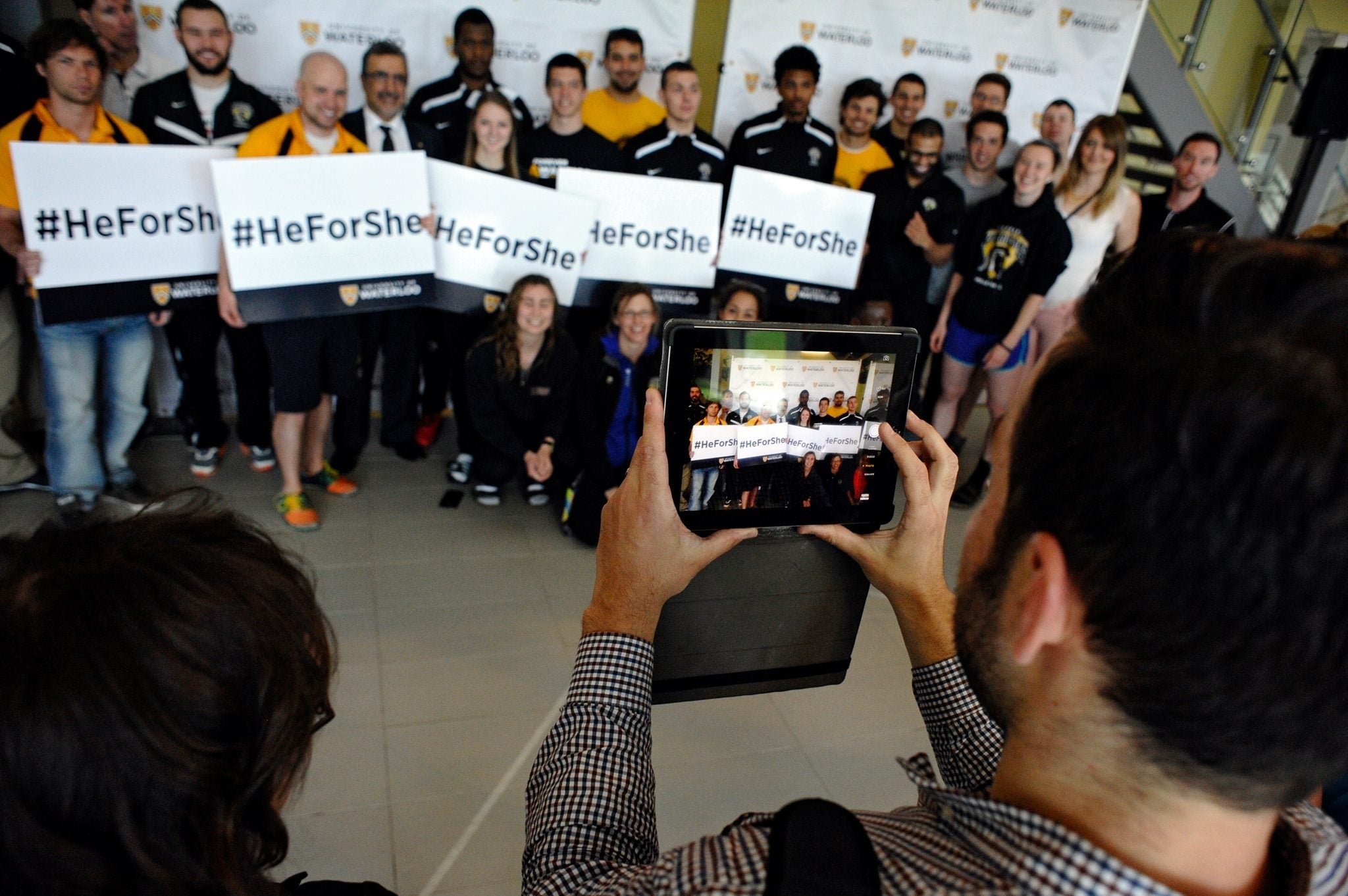 A group photo of people holding HeForShe signs.