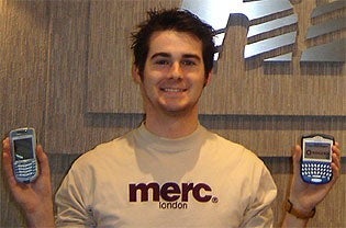 Co-op student Graham Bury shows off two BlackBerry phones in 2005.