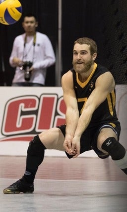 A Warriors volleyball player prepares to hit the ball.