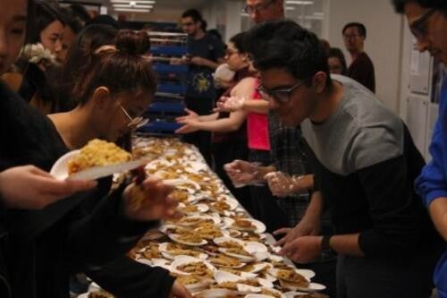 Student volunteers hand out slices of pie to math students.