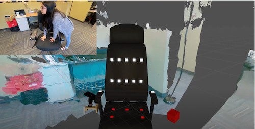 A researcher applies pressure to the seat of the augmented reality chair.