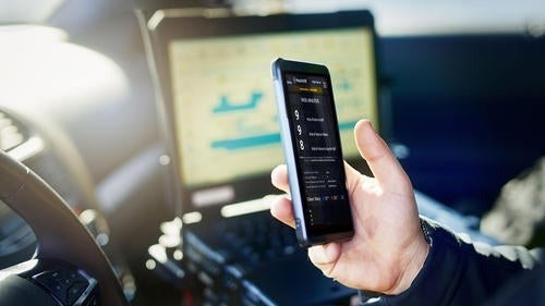 A police officer checks a mobile phone.