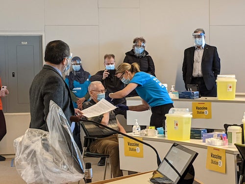 President Hamdullahpur and Vice-President Charmaine Dean look on as a patient receives a dose.