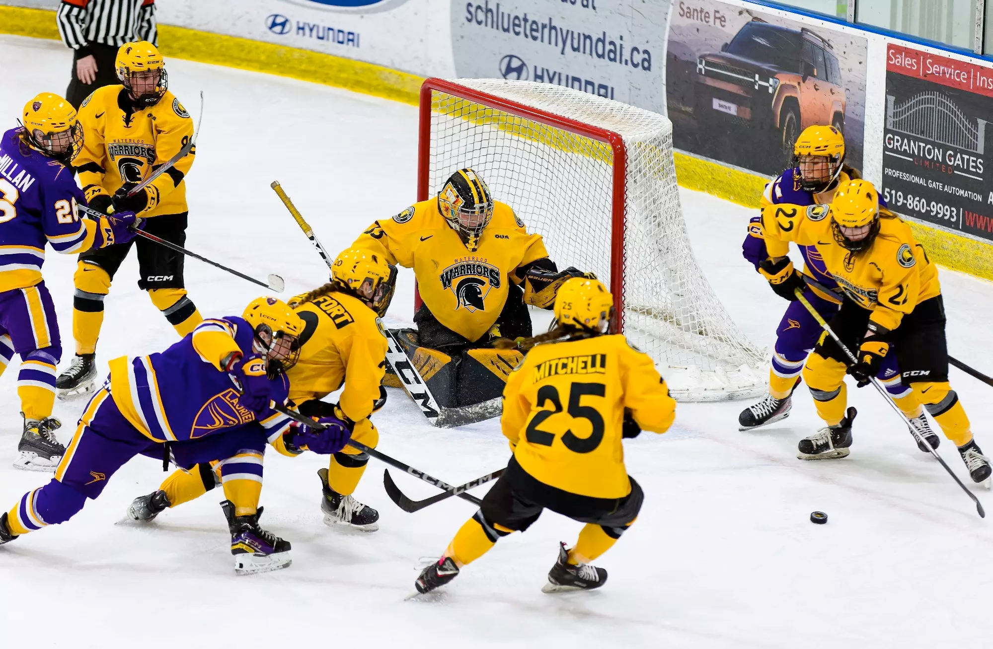 The women's hockey team keeps the puck out of their goalie's net.