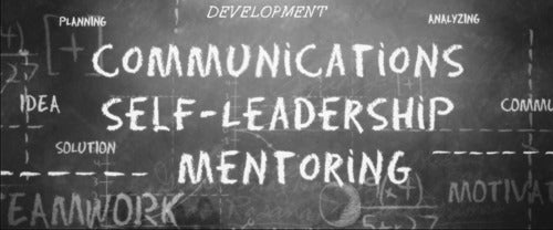 A chalkboard with words on it...it says communications, self leadership and mentoring.