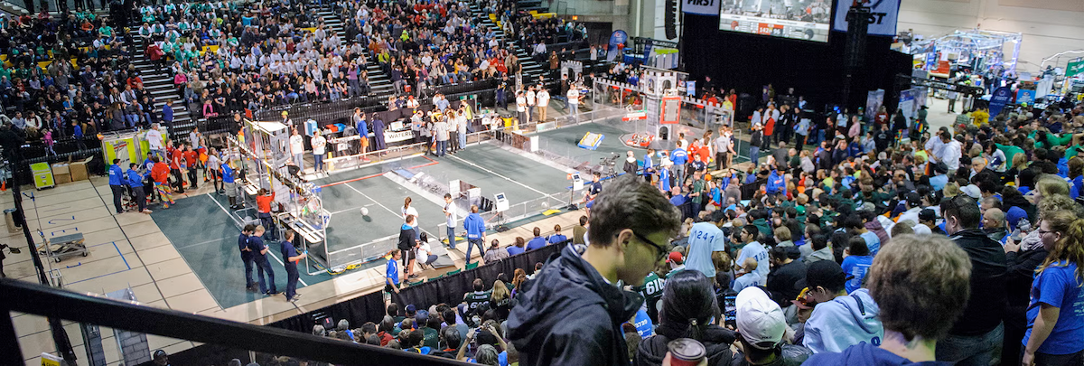 The FIRST robotics competition space in the Physical Activities Complex with crowds of spectators.