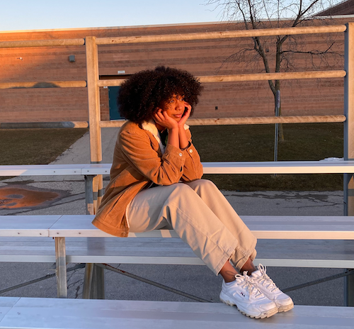 A woman sitting at bleechers smiling