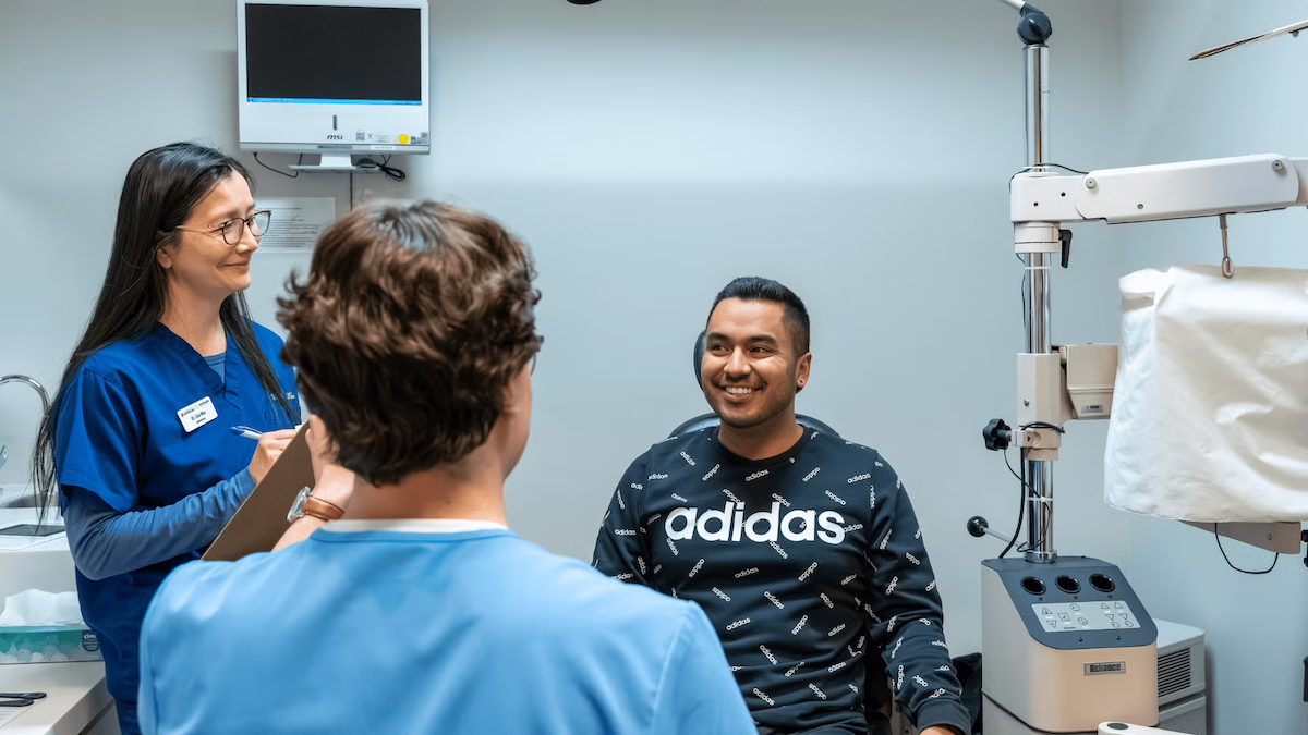 Dr. Lisa Woo supervises an eye exam with a patient.