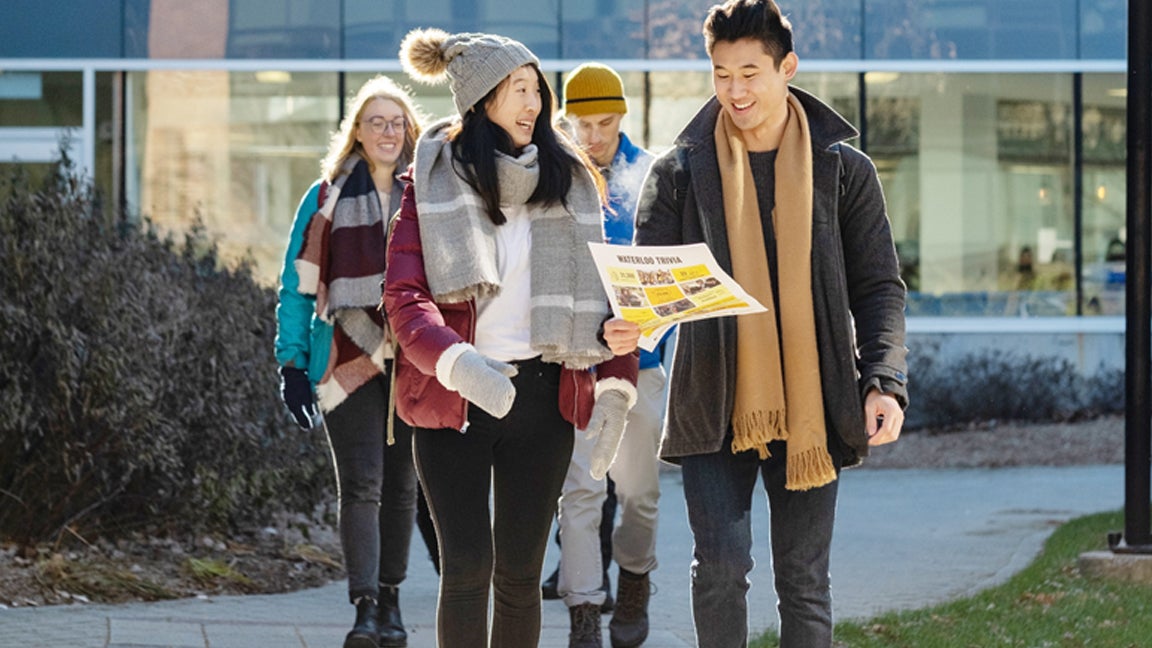 Future students smile as they consult a campus map while on tour.