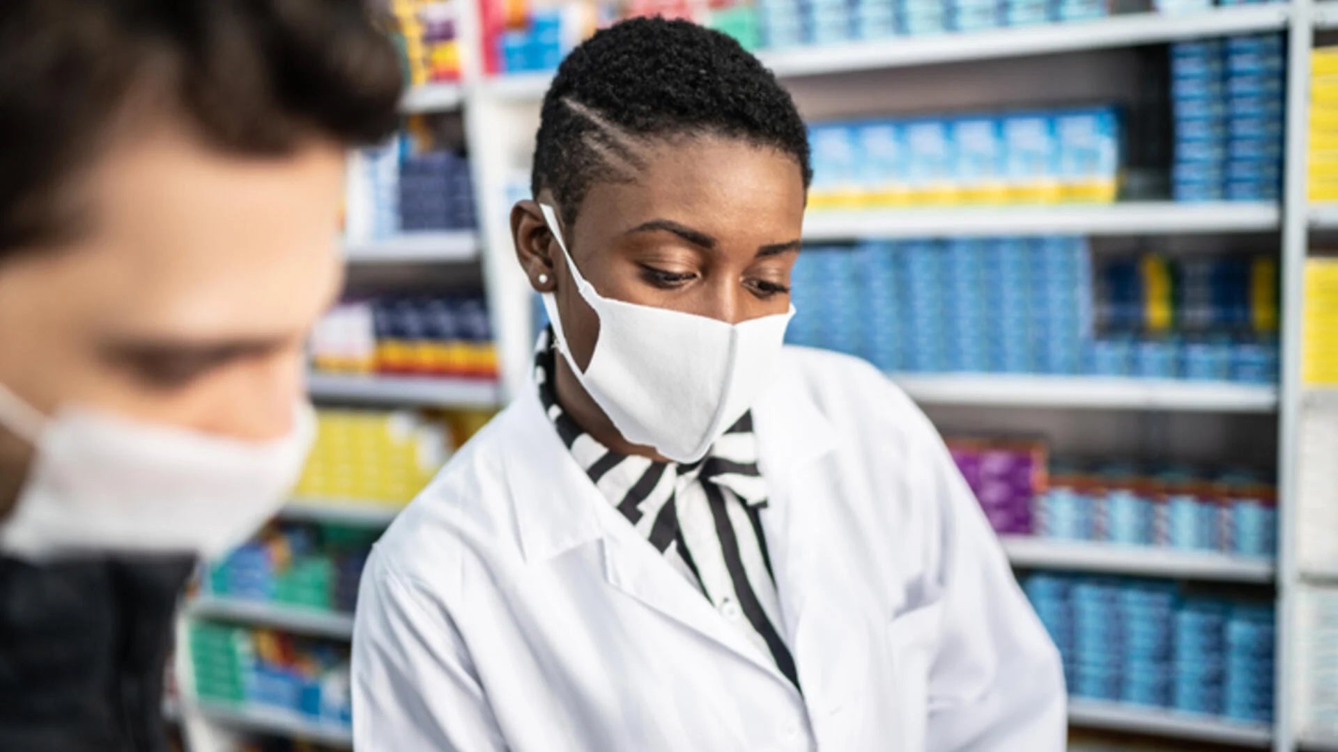 A pharmacist assists a customer.