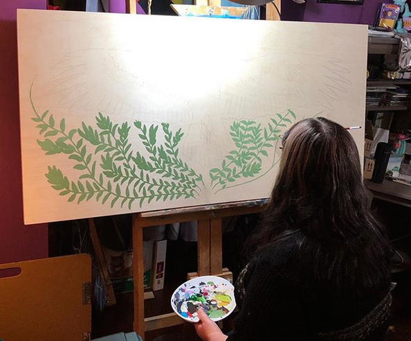 Catherine Dallaire works on a canvas.