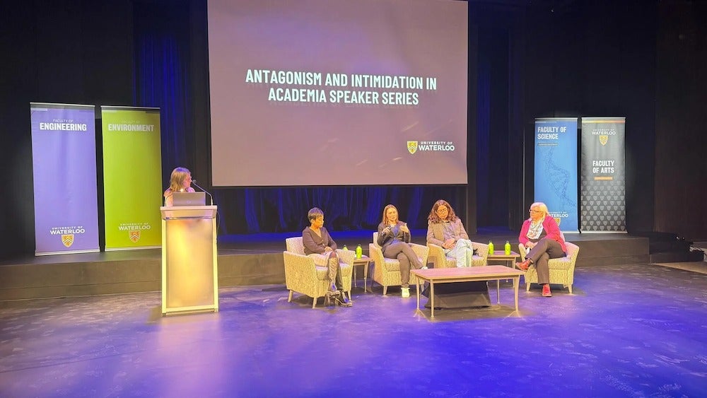 Panelists and moderator on the stage at the Theatre of the Arts.