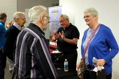 Attendees speak with panelists at the 50th Anniversary event.