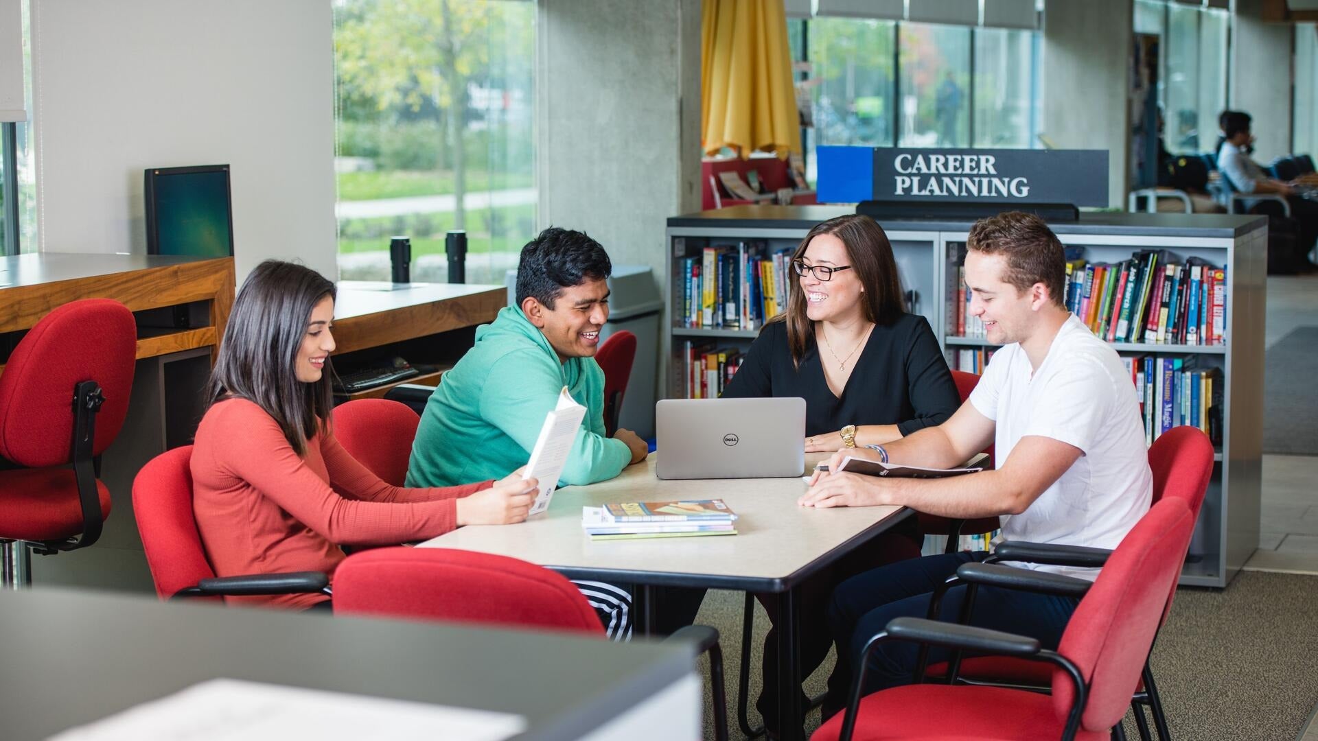 Four students sit at a table in the Centre for Career Action.