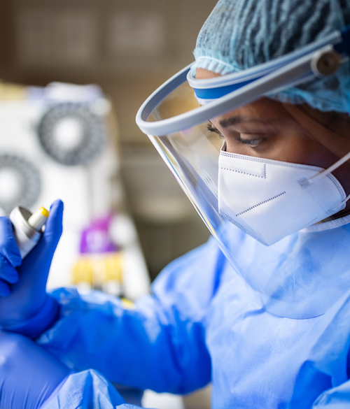 A researcher in full PPE handles volatile liquids.