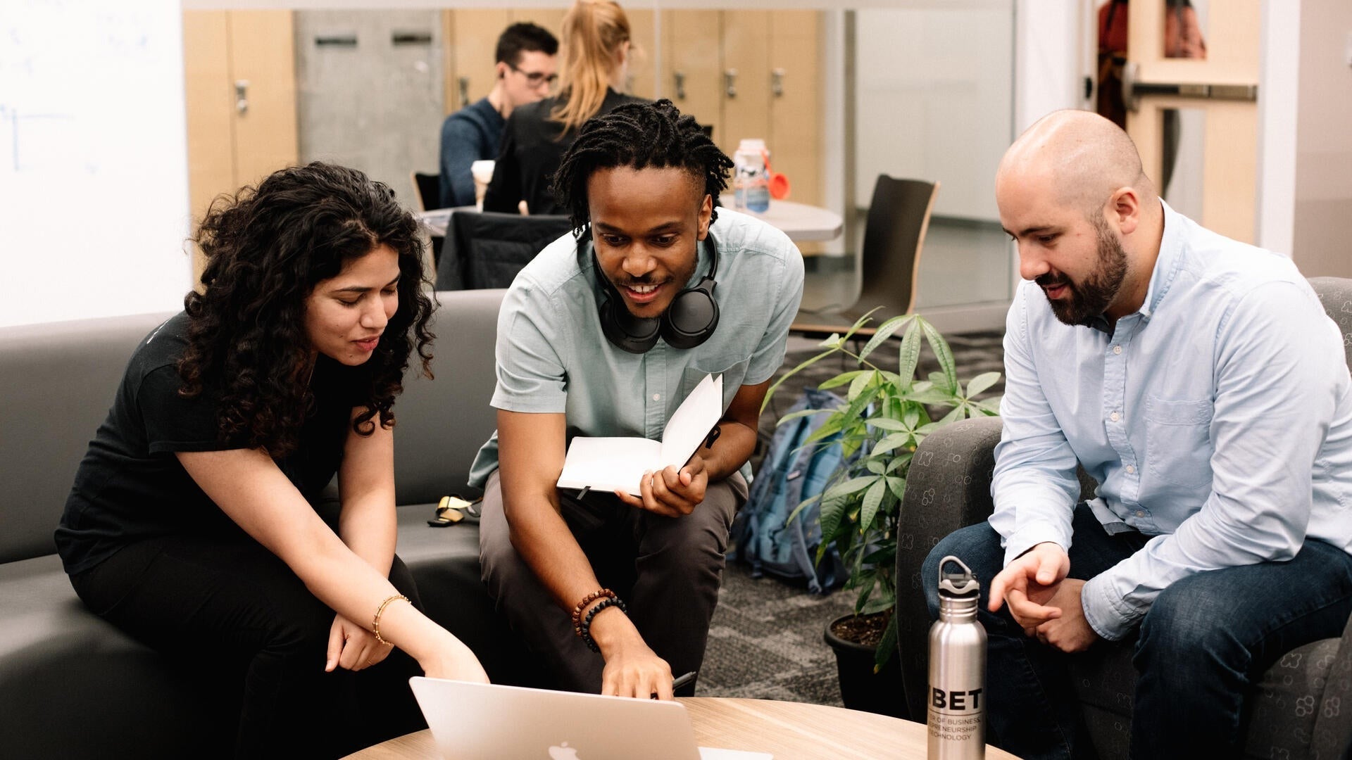 Three Master of Business, Entrepreneurship and Technology students in a collaborative setting.