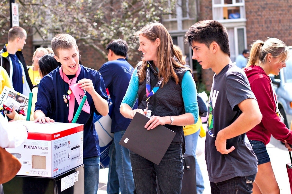 Volunteers help students move into residence.