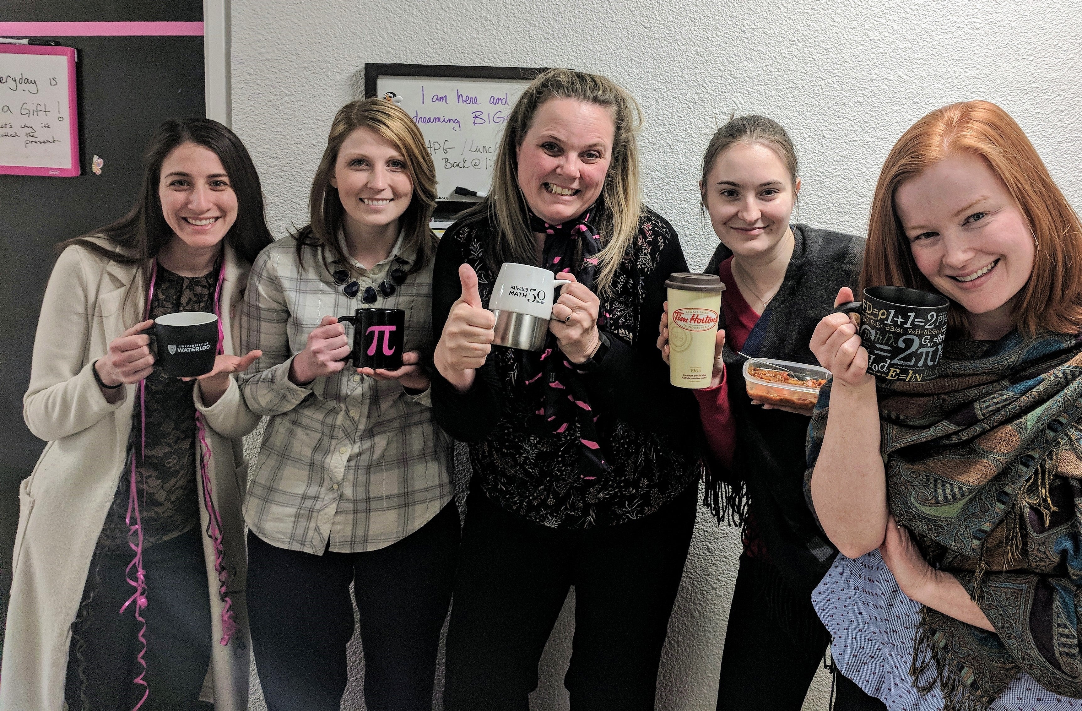 Members of the Mathematics Advancement team pose with their reusable mugs as part of the Green Office Challenge.