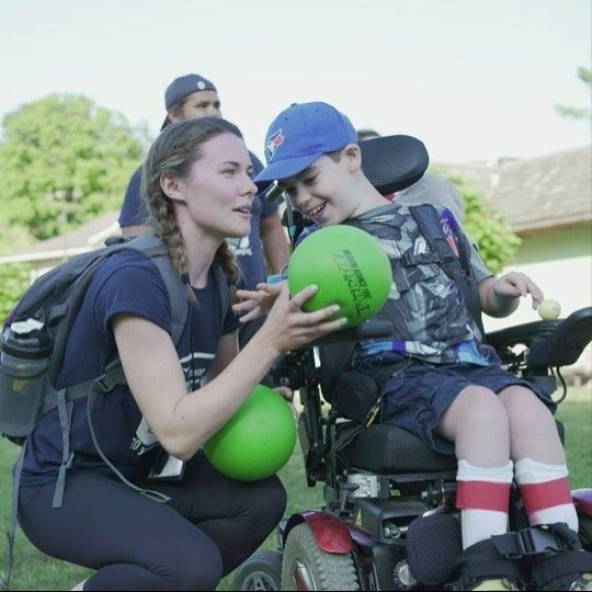 Laurin Black plays with a boy in a wheelchair.